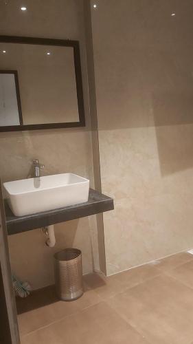 a bathroom with a white sink and a mirror at Hotel Hangout in Jangipur
