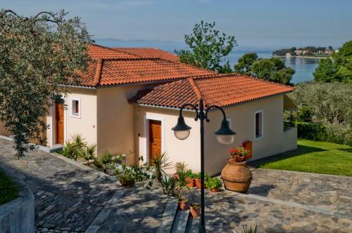 a white house with a red tile roof at Hotel Apartments Sikia in Kato Gatzea