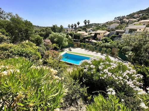 une vue aérienne d'une piscine dans un jardin dans l'établissement Villa Les Bancaous climatisée pour 6 personnes avec piscine privée dans le Domaine de Valcros à La Londe-les-Maures, à La Londe-les-Maures