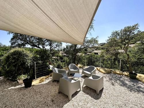 - un groupe de chaises et une table sous une tente dans l'établissement Villa Les Bancaous climatisée pour 6 personnes avec piscine privée dans le Domaine de Valcros à La Londe-les-Maures, à La Londe-les-Maures