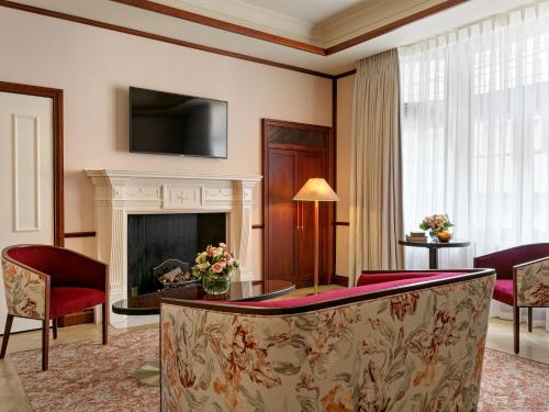 a living room with a fireplace and a tv at The Stafford London in London