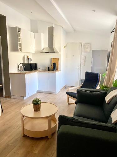 un salon avec un canapé et une table et une cuisine dans l'établissement Beau T3 Spacieux, lumineux et central, à Aix-en-Provence
