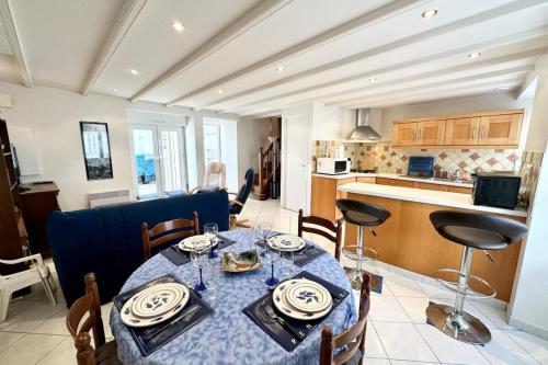 a dining room with a table and a kitchen at Maison de charme Terrasse 5min des plages in Port-Louis
