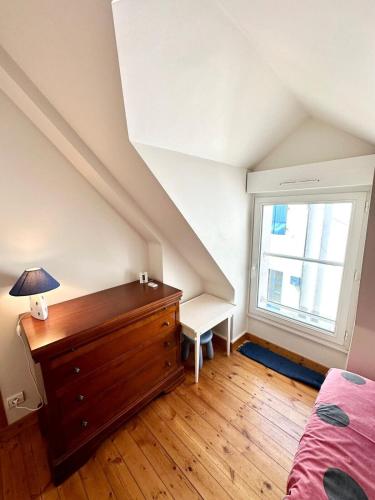 a bedroom with a bed and a dresser and a window at Maison de charme Terrasse 5min des plages in Port-Louis