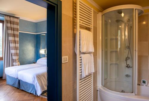 a bedroom with a bed and a shower and a tub at Grand Hotel Bellavista Palace & Golf in Montecatini Terme