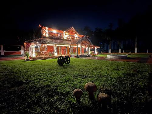 a house lit up at night with mushrooms in the yard at Haveli Holiday Home in Mudigere