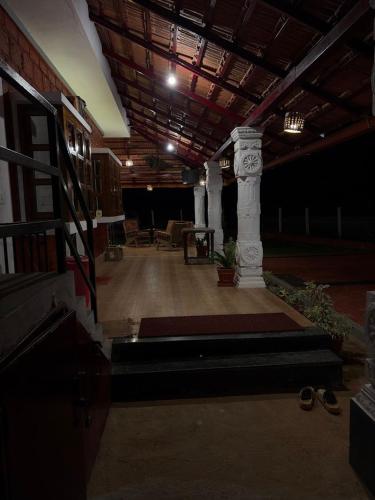 a room with a pillar and some shoes in a building at Haveli Holiday Home in Mudigere