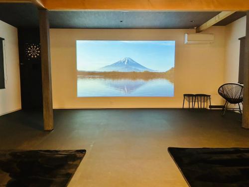a large painting of a mountain on a wall at 室内サウナ 最大18名 川に面する高級貸切宿 下吉田 月江寺駅徒歩圏内 自転車レンタル及び駐車場3台無料 in Fujiyoshida