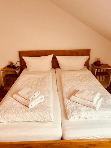 two beds with white sheets and two white towels at Apartments La Rosa in Rust