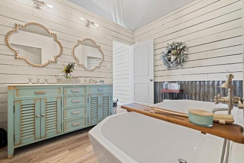 a bathroom with a tub and a sink and mirrors at Mystic Hills Ranch in Fischer