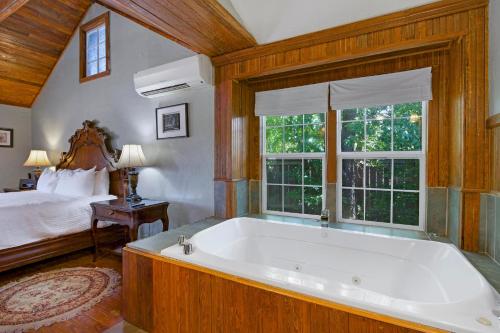 a large bath tub in a bedroom with a bed at Swing On Inn- Rockin Boots Cottage in Dripping Springs