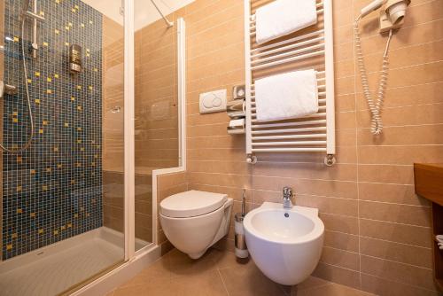 a bathroom with a toilet and a shower and a sink at Hotel Lago Di Garda in Malcesine