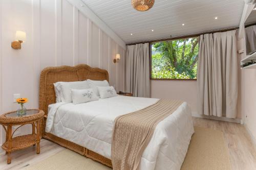 a bedroom with a large bed and a window at Pousada Parador Santarém in Itaipava