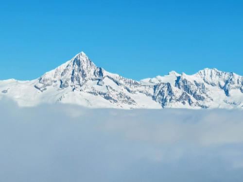 a snow covered mountain with a blue sky at Zur Alten Post - Old Post Office in Grächen