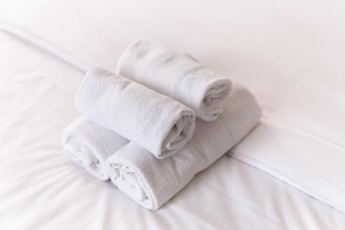 - une pile de serviettes assises sur un lit dans l'établissement Georges V Champs-Élysées Escapade Familiale, à Paris