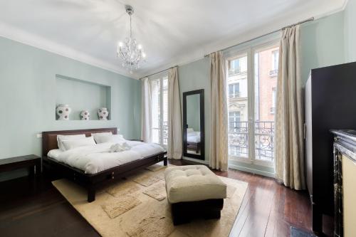 une chambre avec un lit et une grande fenêtre dans l'établissement Georges V Champs-Élysées Escapade Familiale, à Paris