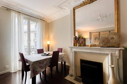 une salle à manger avec une cheminée, une table et des chaises dans l'établissement Georges V Champs-Élysées Escapade Familiale, à Paris