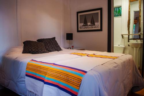 a large bed with a rainbow blanket on it at Idly Lodges in Punta del Este