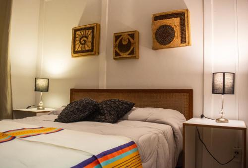 a bedroom with two beds and three pictures on the wall at Idly Lodges in Punta del Este