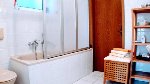 a white bathroom with a tub and a toilet at Solveigs Ferienwohnung in Bad Münstereifel