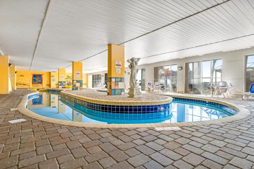 a swimming pool with a fountain in a building at Camelot by the Sea - Oceana Resorts Vacation Rentals in Myrtle Beach