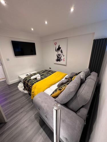 a bedroom with a bed and a couch at Modern House with relaxing Hot tub in Uxbridge