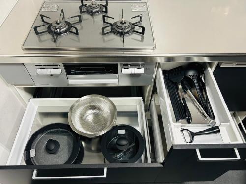 a kitchen with a stove top and a sink at 室内サウナ 最大18名 川に面する高級貸切宿 下吉田 月江寺駅徒歩圏内 自転車レンタル及び駐車場3台無料 in Fujiyoshida