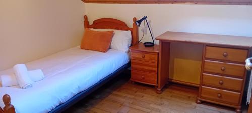 a bedroom with two beds and a wooden dresser at El jardín secreto in Viso