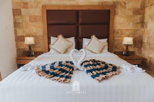 a bed with two towels in the shape of a heart at The paddies villa #2 in Tampaksiring
