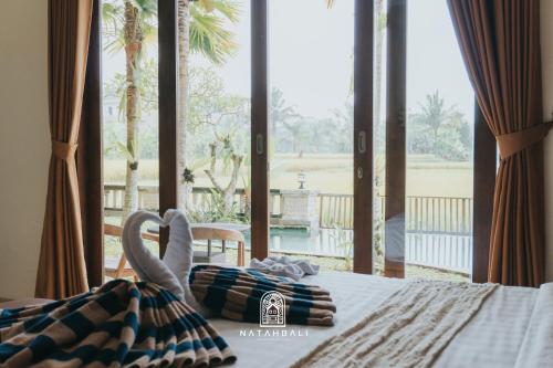 a bedroom with a bed with a view of the ocean at The paddies villa #2 in Tampaksiring