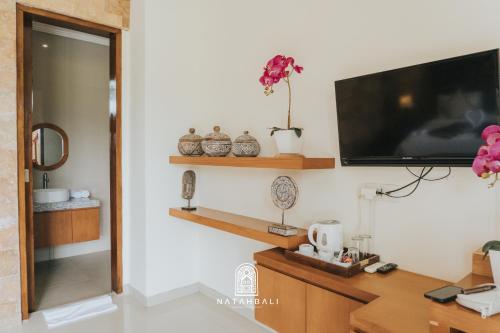 a living room with a flat screen tv on a wall at The paddies villa #2 in Tampaksiring