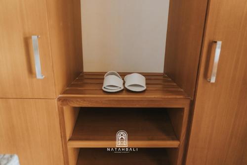 a pair of shoes sitting on a shelf in a closet at The paddies villa #2 in Tampaksiring