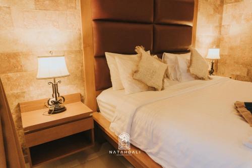 a bedroom with a bed and a lamp on a night stand at The paddies villa #2 in Tampaksiring