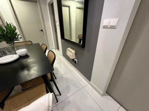 a dining room with a black table and chairs at Arte Cheras The Premium Suites by iLuxHome in Kuala Lumpur