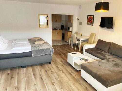 a living room with a bed and a couch at Familien- und Aparthotel Strandhof in Butjadingen OT Tossens