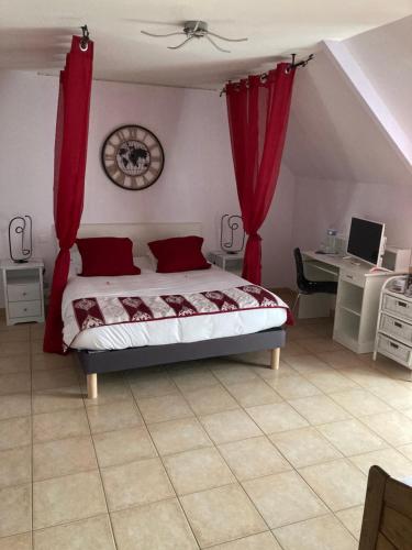 a bedroom with a bed with red curtains and a desk at La Grande Mare in Saint-Benoît-des-Ondes