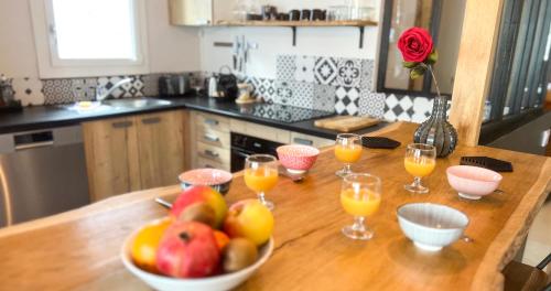 - une table avec un bol de fruits et des verres de jus d'orange dans l'établissement Hypercenter - High Speed WiFi - Close Palais des Papes!, à Avignon
