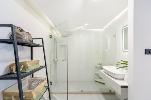 a bathroom with a glass shower and a sink at Zen Style Pool Access Townhouse in Nathon Bay