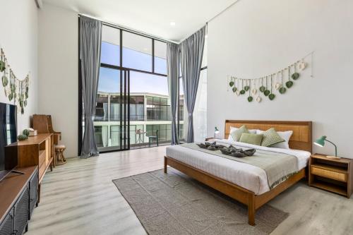 a bedroom with a bed and a large window at Zen Style Pool Access Townhouse in Nathon Bay
