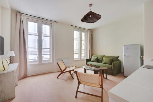 un salon avec un canapé vert et une table dans l'établissement Appartement Triplex à Saint-Germain-des-Prés, à Paris
