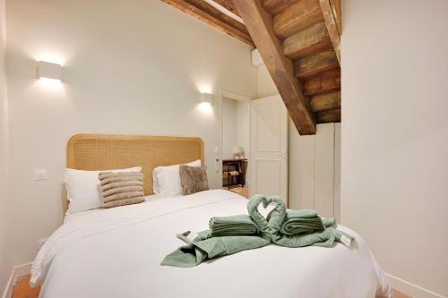 une chambre avec un lit avec une serviette verte dessus dans l'établissement Appartement Triplex à Saint-Germain-des-Prés, à Paris