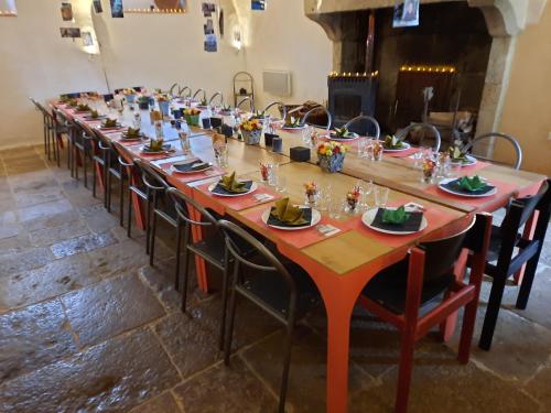 - une longue table dans une pièce entourée de chaises dans l'établissement Chateau Arcade de Sainte Colombe, à Sainte-Colombe