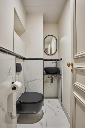 La salle de bains est pourvue de toilettes noires et d'un miroir. dans l'établissement Amazing apartment Saint Germain des Pres with AC by Studio Prestige, à Paris