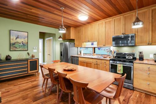a kitchen with a wooden table and a wooden ceiling at Cypress Star in Wimberley