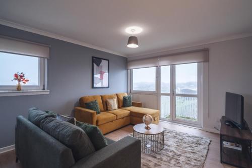 a living room with a couch and a tv at Franklin Place in East Kilbride