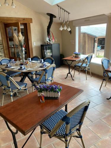 a dining room with wooden tables and chairs at La Grande Mare in Saint-Benoît-des-Ondes