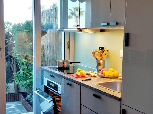 d'une cuisine avec un comptoir, un évier et une fenêtre. dans l'établissement Grand studio avec terrasse à 20 m de la plage, à Nice