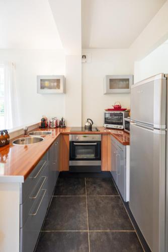 a kitchen with stainless steel appliances and wooden counters at Domaine des Chanoines blancs in Gouy-Saint-André