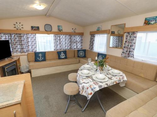a living room with a table and a couch at MillRythe Holiday Park Dunlin Walk 13 in North Hayling
