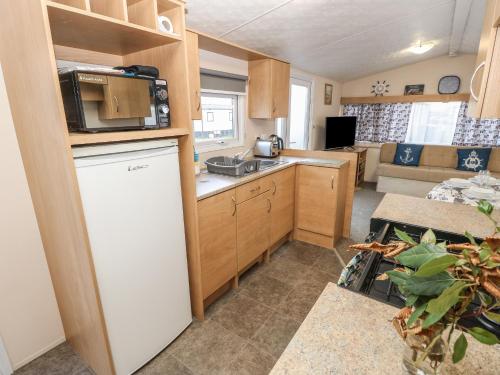 a small kitchen with a sink and a refrigerator at MillRythe Holiday Park Dunlin Walk 13 in North Hayling
